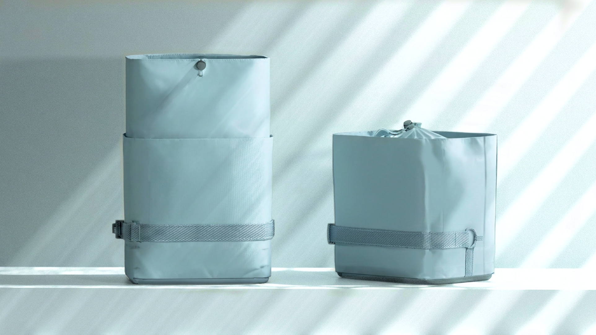 Two Fello laundry transport systems shown in different sizes against a soft studio backdrop